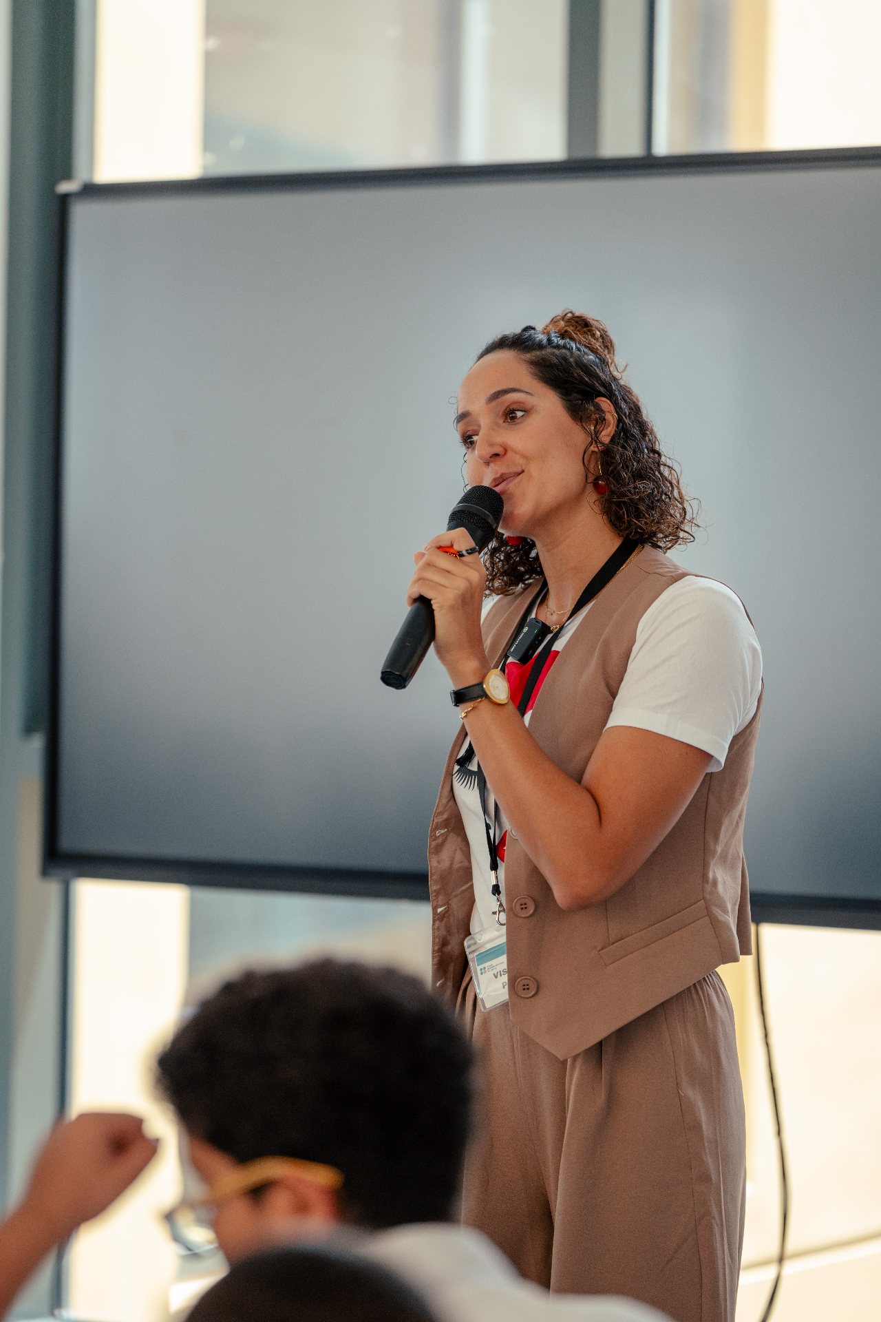 Dr Sarra Lajnef-Taylor delivering a keynote address with a handheld microphone