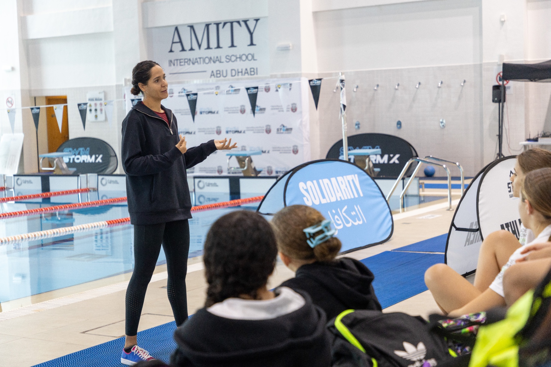 Dr Sarra Lajnef-Taylor delivering a pre-meet briefing to swimmers at Storm Swimming Academy